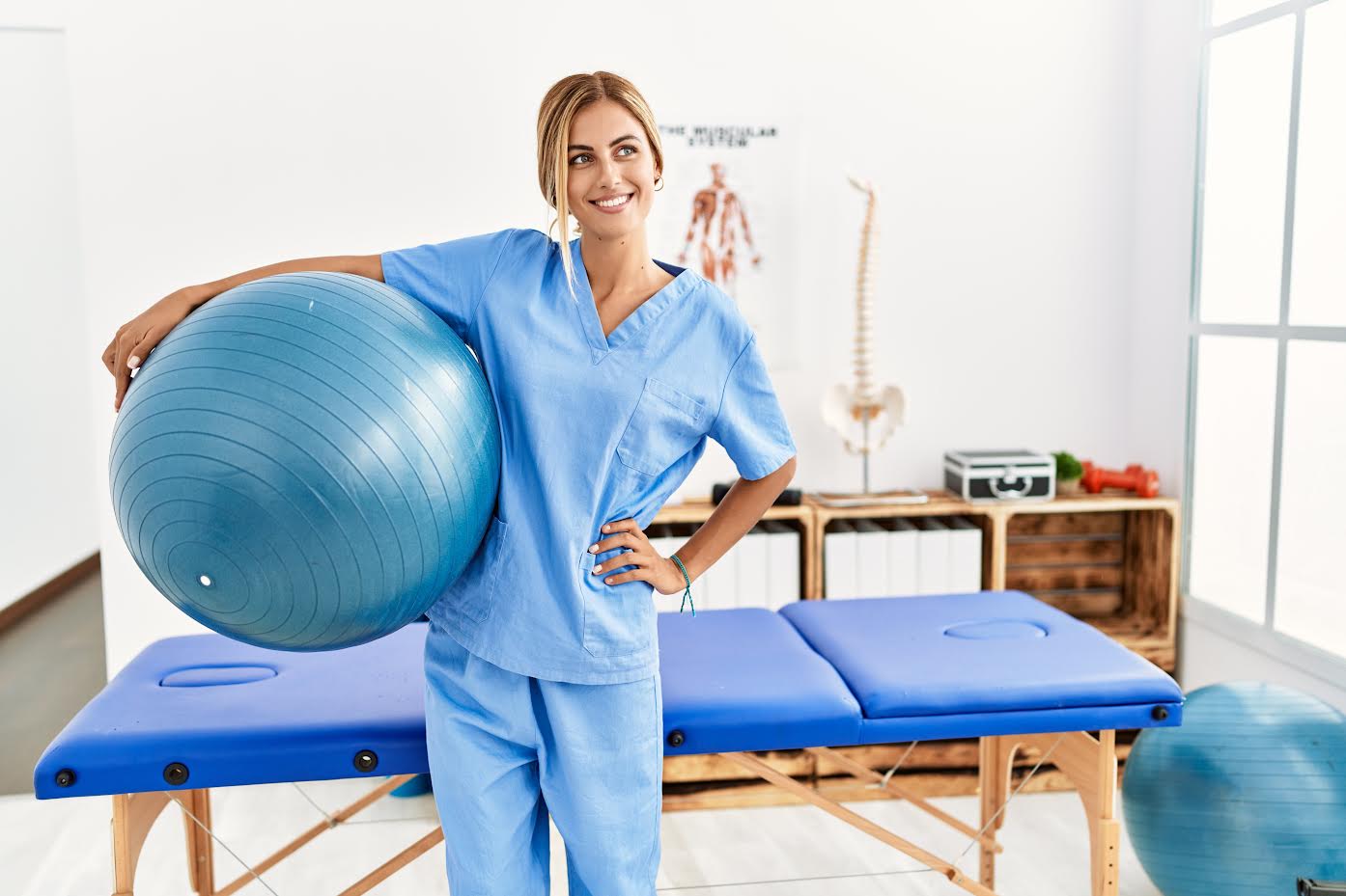 Young caucasian physio therapist smiling happy standing at the clinic