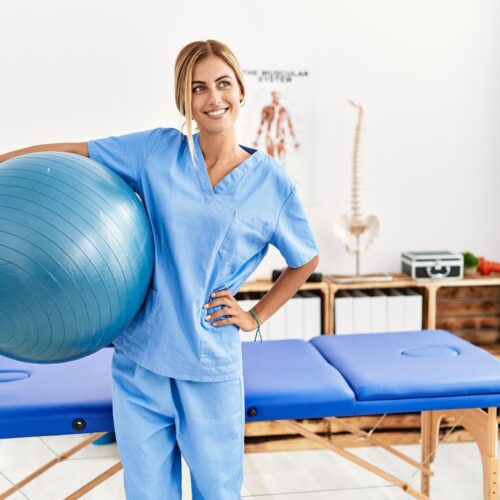Young caucasian physio therapist smiling happy standing at the clinic